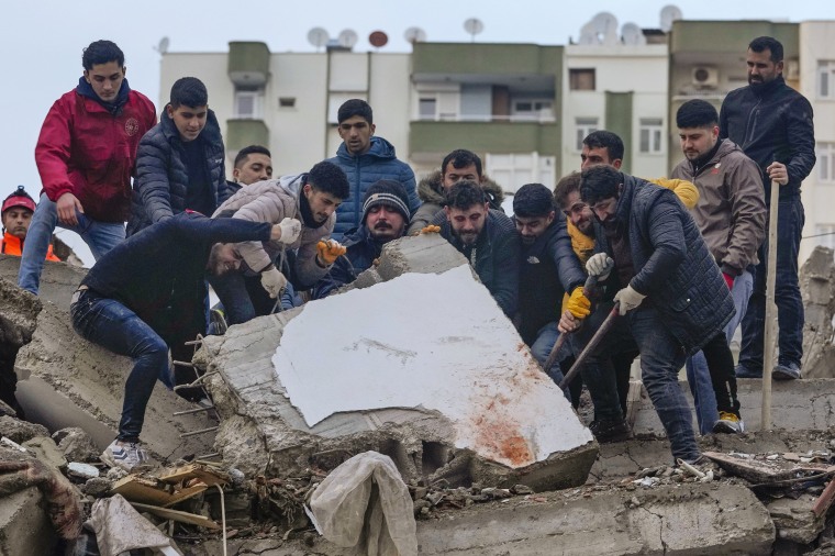 Men search for survivors in the debris in Adana, Turkey, on Feb. 6, 2023.