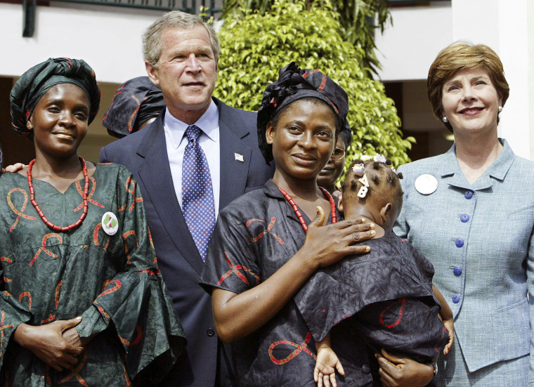 President George W. Bush and first lady Laura Bush greet local mothers affected by AIDS with their HIV-free children in the courtyard of the Abuja National Hospital and laboratory in Abuja, Nigeria, the last stop on his African tour, on July 12, 2003.