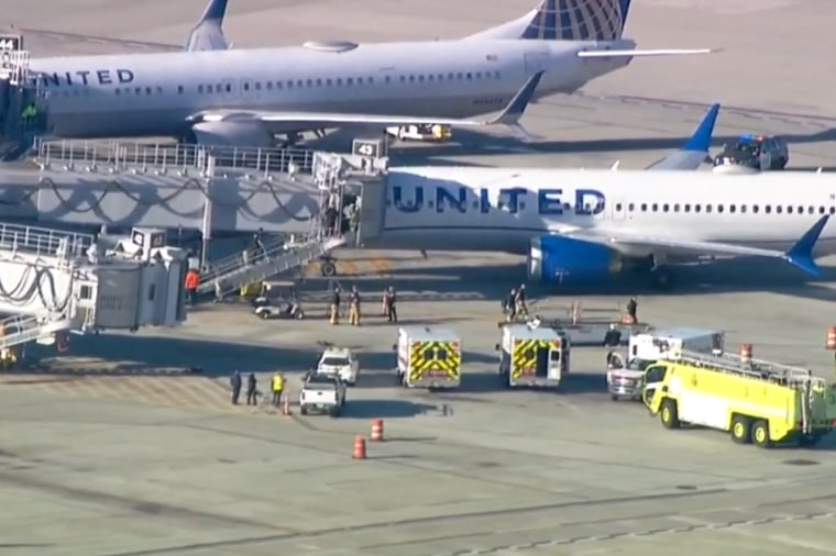 Emergency services work near a United Airlines plane after it landed due to a fire in San Diego on Tuesday.