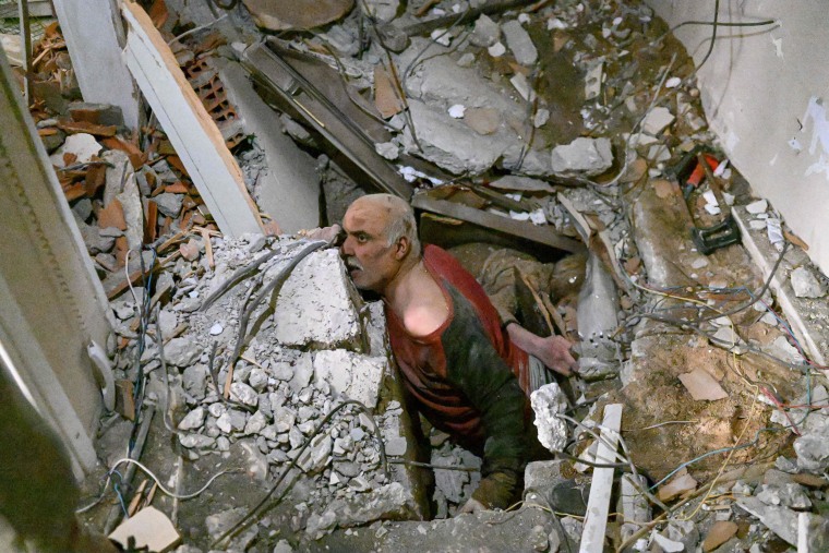 A man trapped in rubble reacts as debris is removed to rescue him in Hatay, Turkey, on Feb. 7, 2023