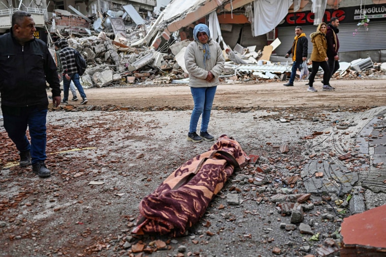 A woman weeps as she stands beside the body of a victim in Hatay, Turkey, on Feb. 7, 2023.