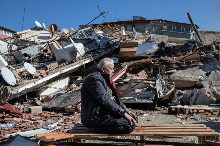 A man prays in front of a collapsed building on Feb. 8, 2023 in Hatay, Turkey.