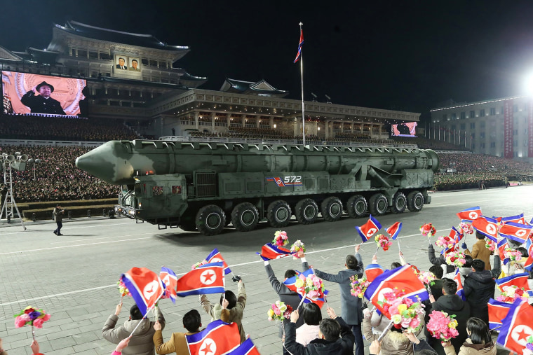 An intercontinental ballistic missile is paraded past cheering crowds gathered in Kim Il Sung square. 