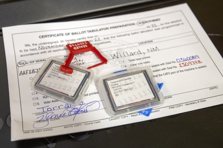 Data flash cards sit on certification forms for ballot-counting machines bearing the signature of Torrance County Clerk Yvonne Otero as testing begins at a county warehouse in Estancia, N.M., on Sept. 29, 2022. 