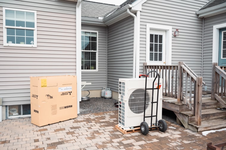 An electric heat pump sits ready to be installed by a crew from ReVision Energy, a New England company specializing in solar energy and electric heat pump installations, at a home in Windham, Maine on Jan. 19, 2023.