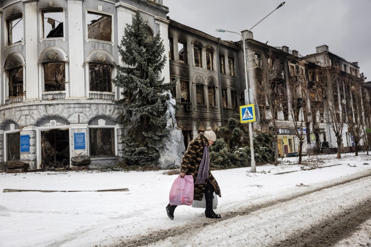 A resident carries humanitarian aid while walking through a nearly deserted downtown area on Feb. 14, 2023 in Bakhmut, Ukraine.