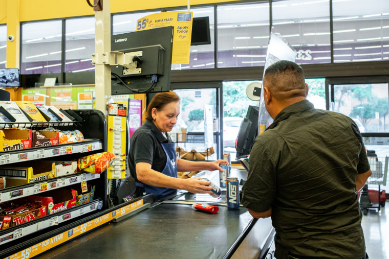A cashier rings up a customer in a grocery store