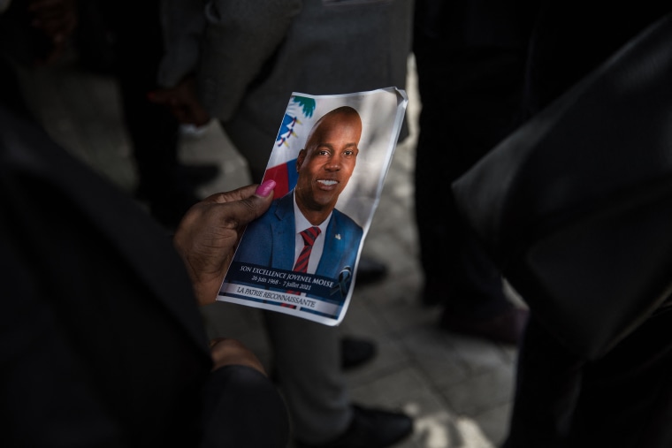A guest holds a picture of late Haitian President Jovenel Moise during a ceremony in Port-au-Prince, Haiti, on July 20, 2021.