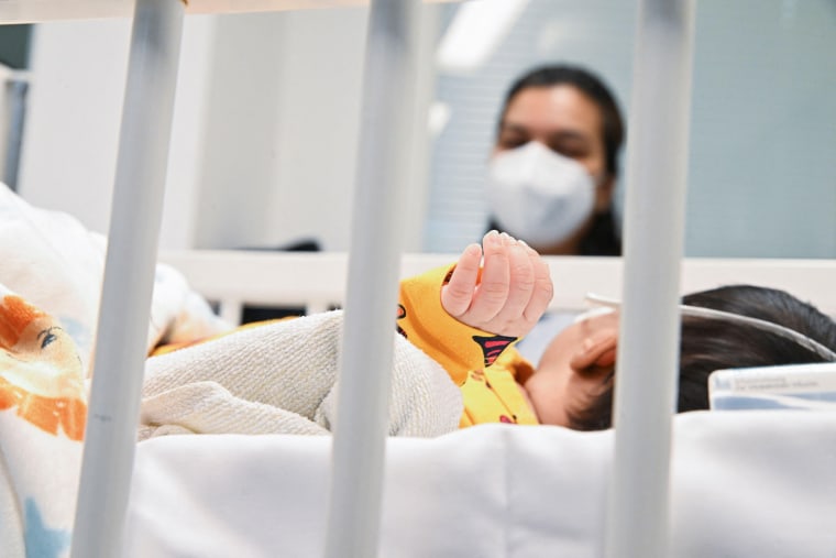 A mother watches her child who is suffering from an RSV infection in a pediatric intensive care unit Sankt Augustin, Germany, on Dec. 6, 2022.