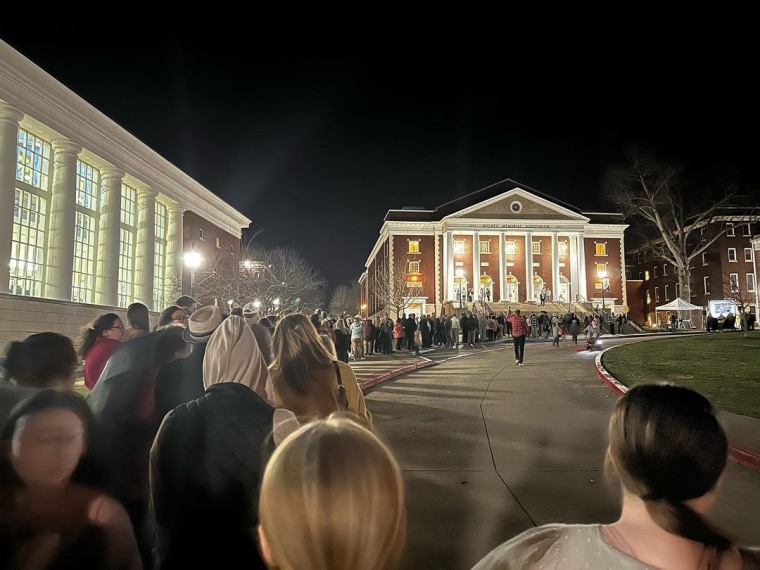 A photograph of Asbury University's campus, filled with students marching towards the church.