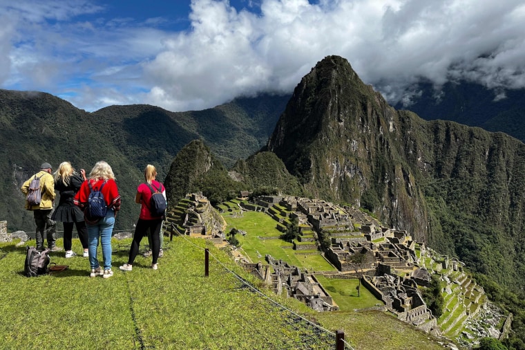 Tourists visit the ancient Inca ruins of Machu Picchu in the Urubamba valley, near cusco, Peru