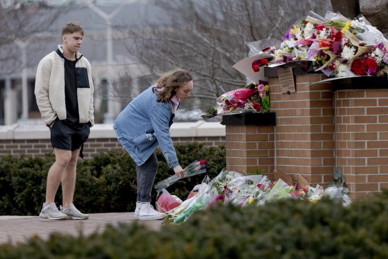 People place flowers at the Spartan Statue at Michigan State University in Lansing, Mich.