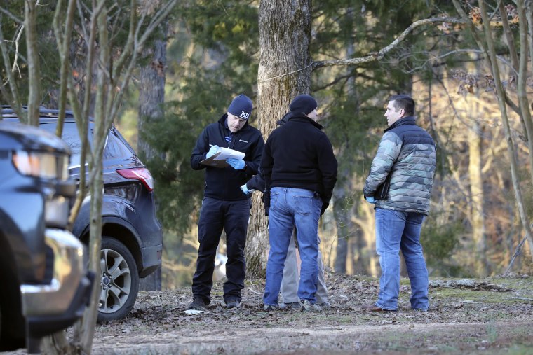 Law enforcement personnel investigate the scene of multiple shootings on Arkabutla Dam Road in Arkabutla, Miss.