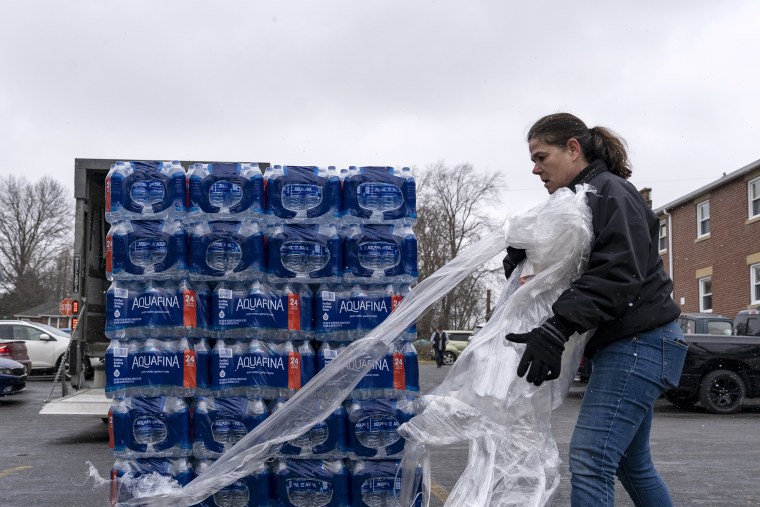 A volunteer prepares to distribute cases of water to residents in East Palestine, Ohio