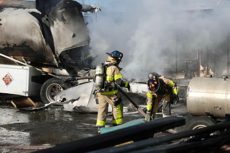 Emergency personnel work at the scene of an explosion at a welding business