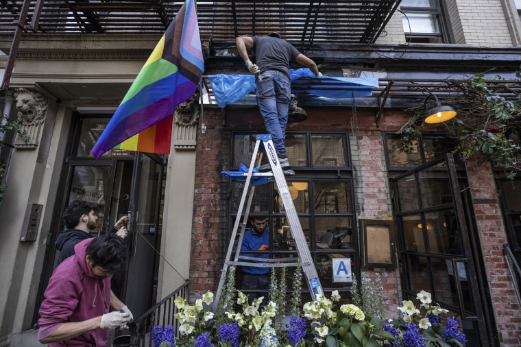 Workers repair damage to Little Prince caused by an arsonist who ignited a gay pride flag hanging from the restaurant's facade, in Manhattan's SoHo neighborhood, Feb. 20, 2023.
