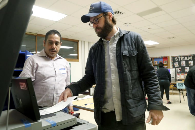 Dallas County election worker Maxx Nuñez helps Democrat Jamie Wilson cast his ballot in the Super Tuesday primary at John H. Reagan Elementary School in the Oak Cliff section of Dallas, Tuesday, March 3, 2020.