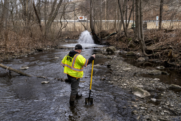 Un trabajador de respuesta a emergencias de la EPA de Ohio busca signos de peces y también agita el agua de Leslie Run Creek para buscar productos químicos que se hayan depositado en el fondo tras el descarrilamiento de un tren el 20 de febrero de 2023, en el este de Palestina.