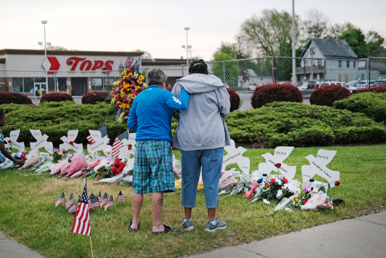 People gather at a memorial for the shooting victims outside of Tops market in Buffalo, N.Y.