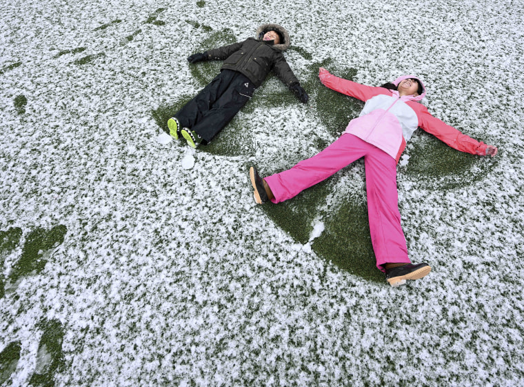 Jacob Polanco, left, 8, and his older sister Khloe, 9, make snow angels in Rancho Cucamonga, Calif., on Saturday, Feb. 25, 2023. 