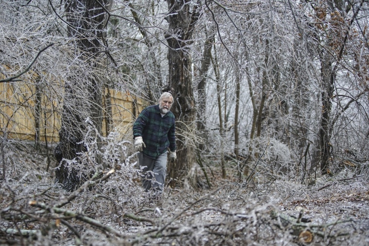 Mark Miller cleans up debris after ice storm damage in Kalamazoo Township, Mich.