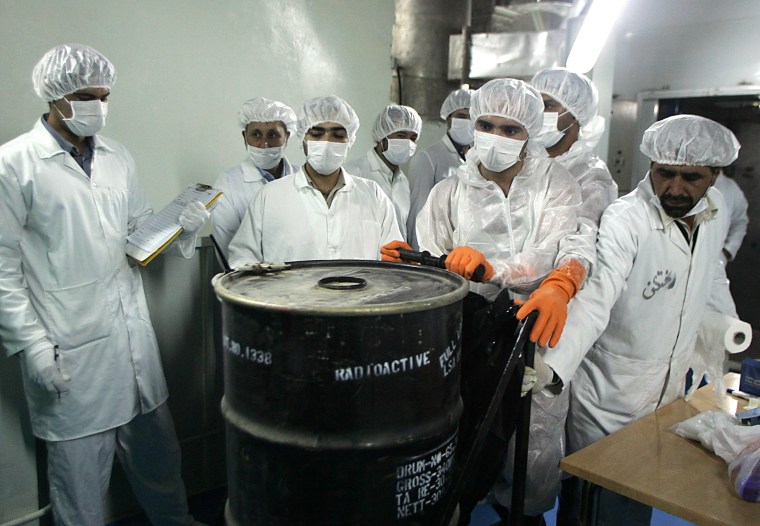 Iranian technicians remove a container of radioactive uranium, 'yellow cake', sealed by the International Atomic Energy Agency, to be used at the Isfahan Uranium Conversion Facilities