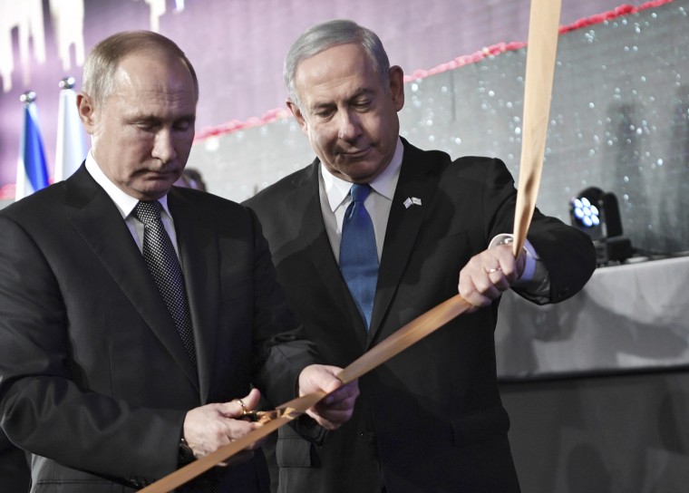 Russian President Vladimir Putin cuts a ribbon with Israeli Prime Minister Benjamin Netanyahu at an unveiling ceremony of the Remembrance Candle for World War II heroes of besieged Leningrad on Jan. 23, 2020 in Jerusalem.