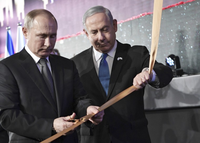 Russian President Vladimir Putin cuts a ribbon with Israeli Prime Minister Benjamin Netanyahu at a ceremony unveiling the candle in remembrance of World War II heroes of besieged Leningrad January 23, 2020 in Jerusalem.