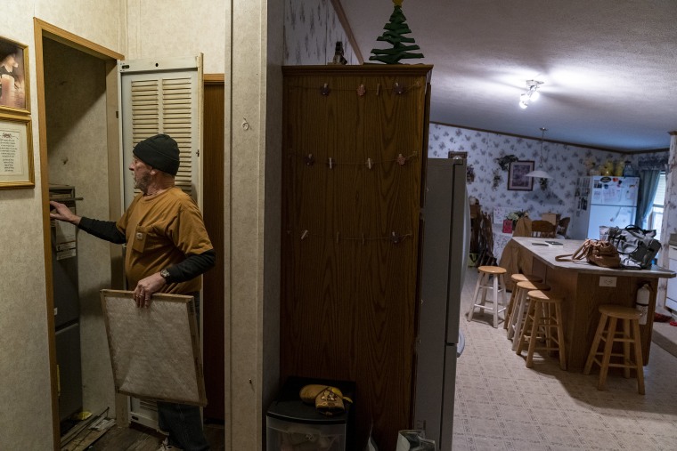 Jerry Barber changes the filter on a furnace in his home after receiving free filters from a donation bank on February 17, 2023 in Darlington, Pennsylvania.