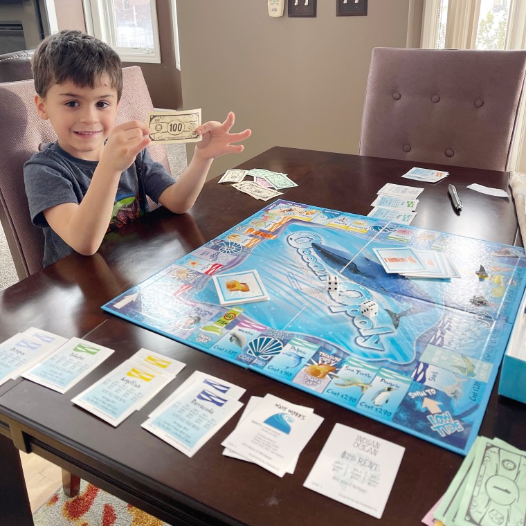 Mason Stonehouse playing with Monopoly money.