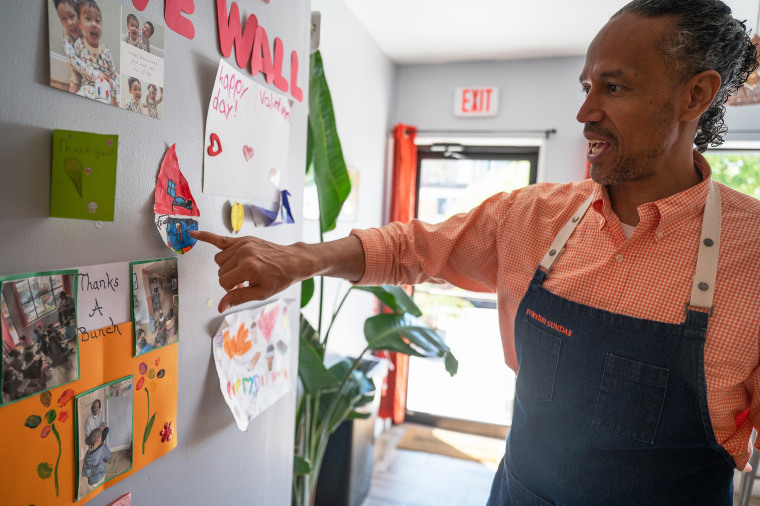 Owner Charles Foreman shows off his wall of love with notes from kids and others in the neighborhood inside his ice cream shop Everyday Sundae.