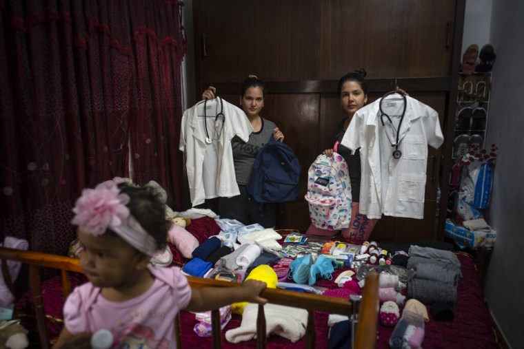 Melanie Rolo González, a la derecha, y su hermana Merlyn, mientras empacaban provisiones y medicinas para su travesía hacia Estados Unidos, en su casa en La Habana, Cuba, el 10 de diciembre de 2022.