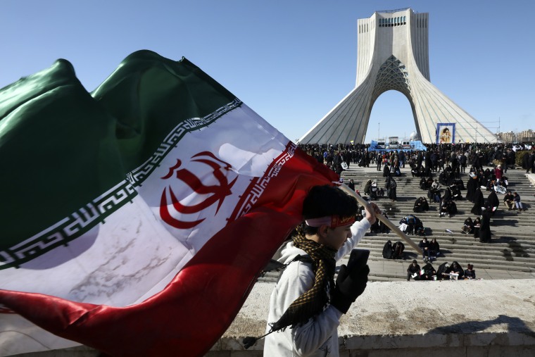Un niño lleva una bandera iraní frente a la torre del monumento Azadi (Libertad) en una manifestación para celebrar el 41 aniversario de la Revolución Islámica, en Teherán, Irán, martes 11 de febrero de 2020. 