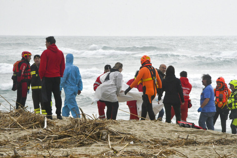 Rescatistas recuperan un cuerpo en una playa cercana a Cutro, en el sur de Italia, el domingo 26 de febrero de 2023.