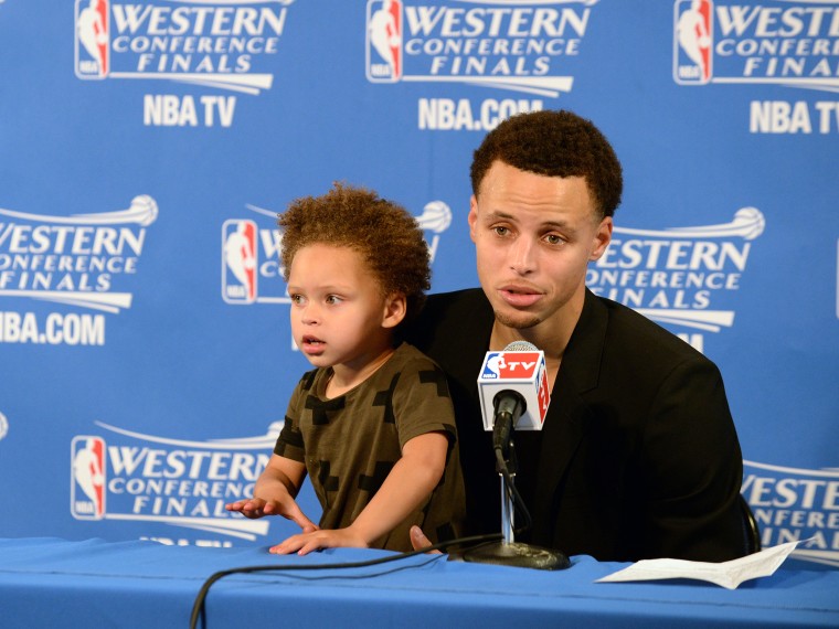 Stephen Curry #30 of the Golden State Warriors and his daughter Riley talking with the media at a press conference after the game against the Houston Rockets during Game One of the Western Conference Finals during the NBA Playoffs on May 19, 2015 at ORACLE Arena in Oakland, California.