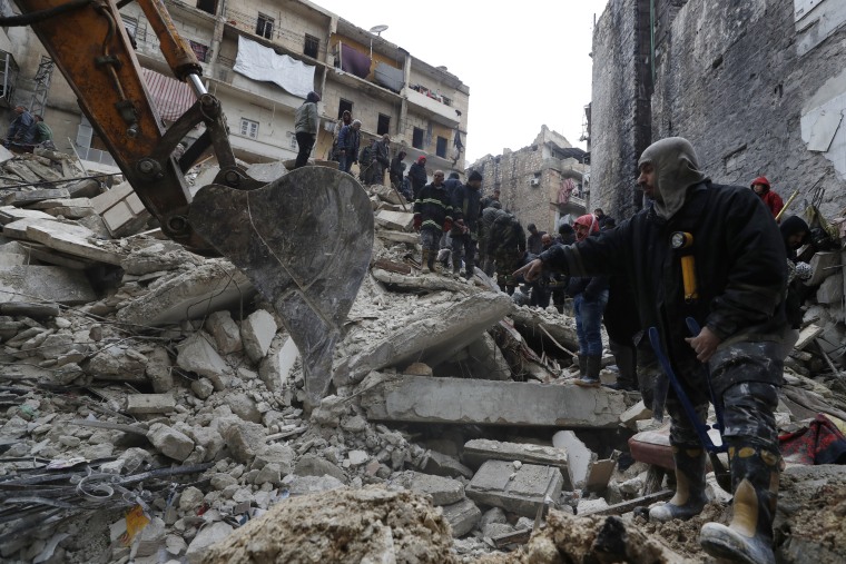 Trabajadores de la Defensa Civil Siria y fuerzas de seguridad buscan entre los escombros de edificios derrumbados, en Alepo, Siria, lunes 6 de febrero de 2023.
