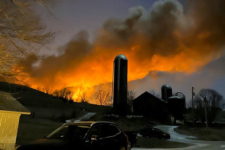 Foto facilitada por Melissa Smith en las que se aprecian llamas y humo provenientes de vagones descarrilados, tomada desde su granja en East Palestine, Ohio, el viernes 3 de febrero de 2023. (Melissa Smith vía AP)