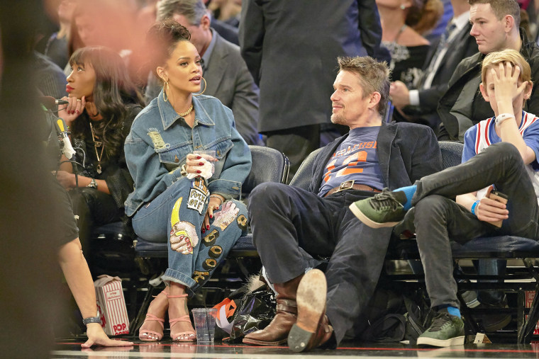 Rihanna and Ethan Hawke sitting courtside during Team East vs Team West game.