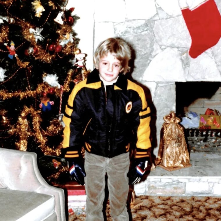 Younger Bublé poses for the camera with holiday decorations in the background.