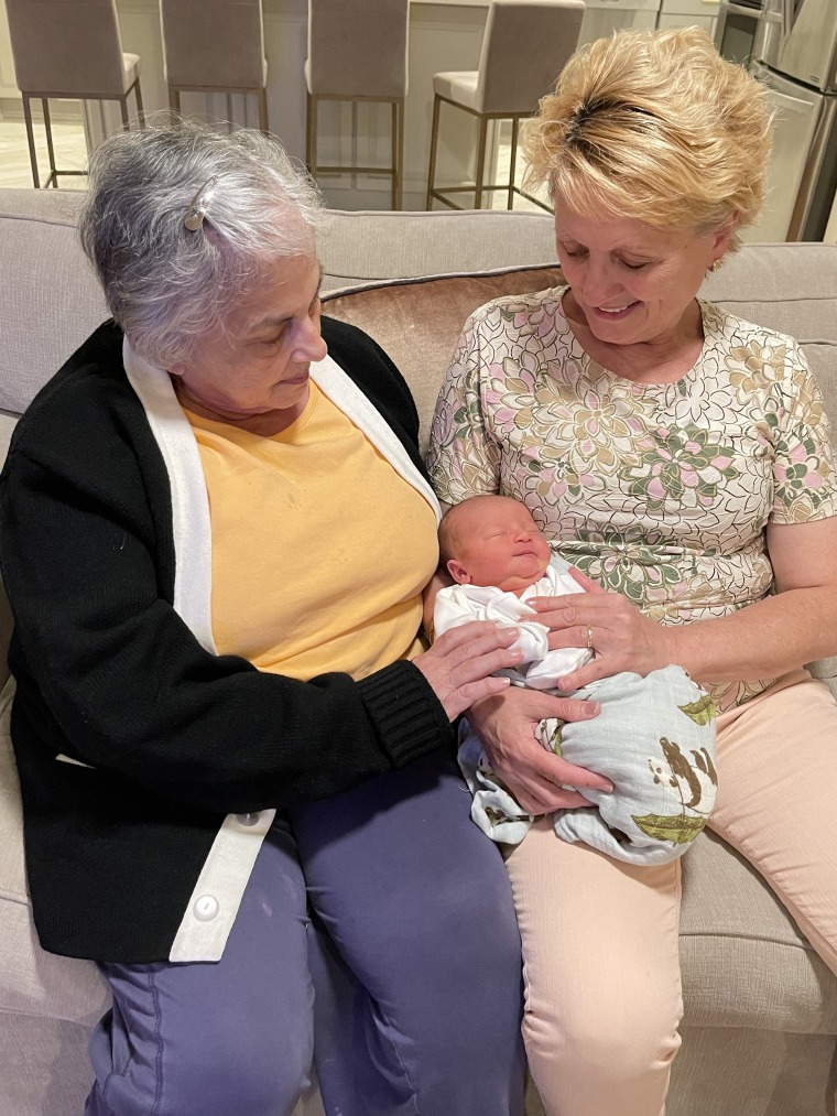 The proud "nonnas" holding their grandbaby.