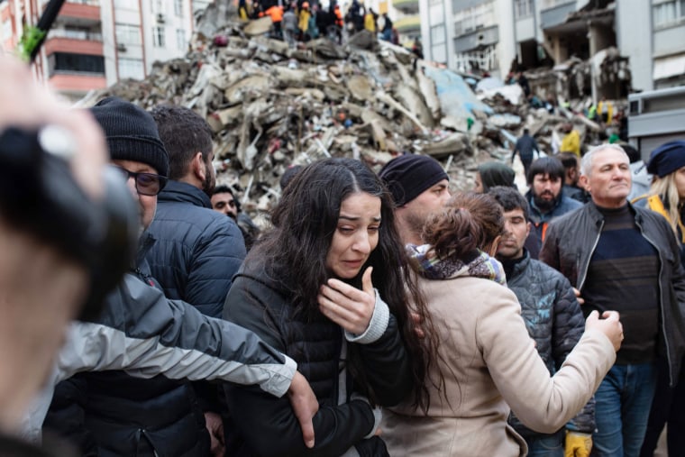 A woman reacts as rescuers search for survivors through the rubble in Adana, Turkey, on Feb. 6, 2023. 