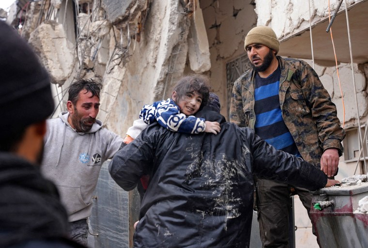 Residents retrieve a child from the rubble in Jandaris in a rebel-held area of Syria's Aleppo province.