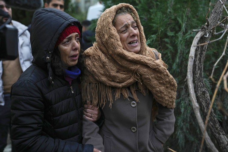 Women watch the rescue efforts in Adana, Turkey. 