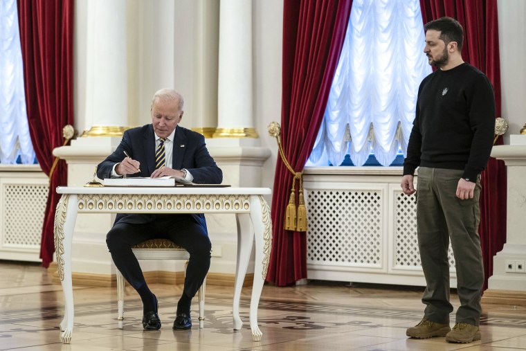 Image: Ukrainian President Volodymyr Zelenskyy watches as President Joe Biden signs the guest book at Mariinsky Palace during a surprise visit, Feb. 20, 2023, in Kyiv.