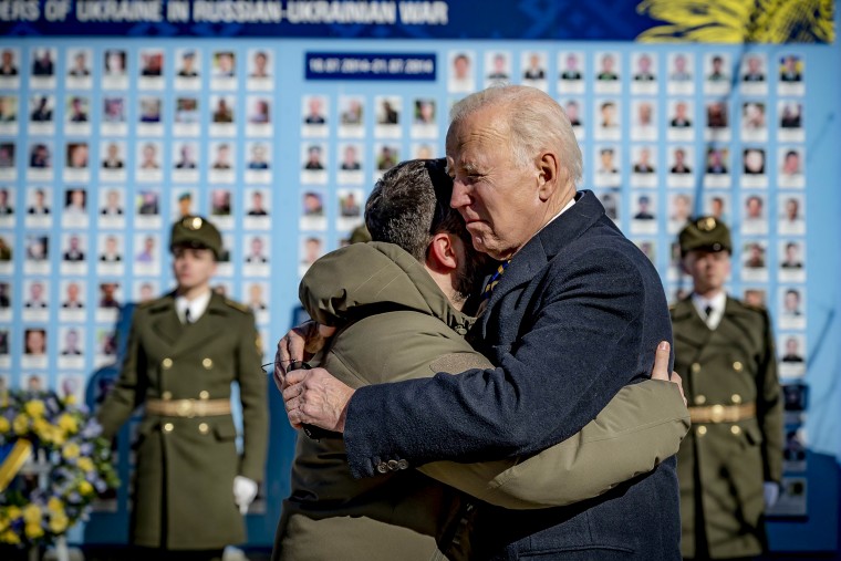 Image: President Joe Biden, right, and Ukrainian President Volodymyr Zelenskyy hug as they say goodbye at the Memorial Wall of Fallen Defenders of Ukraine in Russian-Ukrainian War with photos of killed soldiers, in Kyiv, Ukraine, on Feb. 20, 2023.