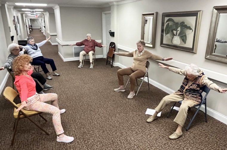 Bailey, seated first on the right, goes through exercises designed to move all parts of the body.