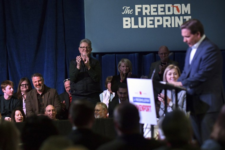 A member of the crowd applauds Florida Gov. Ron DeSantis in Davenport, Iowa, 