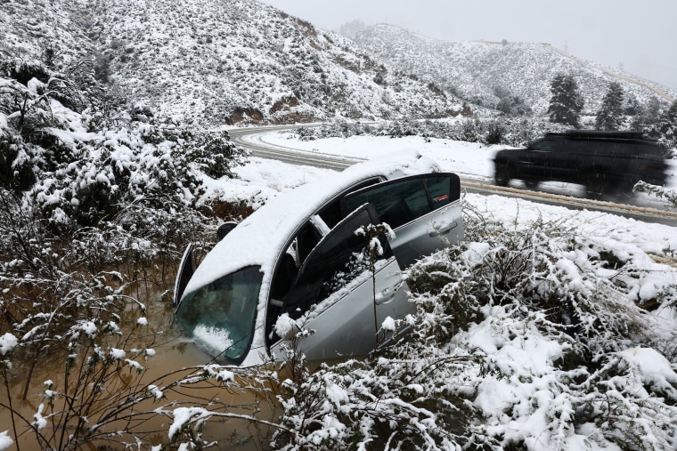 A vehicle which skidded off the snowy roadway into a small pond near Green Valley, Calif., on Feb. 25, 2023.