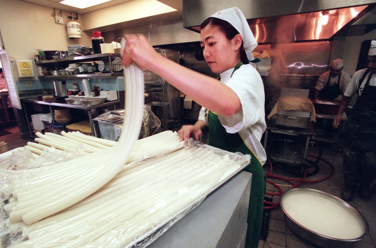 Yumi Yang separa los pasteles de arroz tteokbokki antes de cortarlos en San Su Jang Rice Pastry en Los Ángeles.