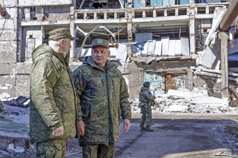 Russian Defense Minister Sergei Shoigu, center, speaks to an officer in Ukraine 